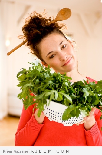 Young woman with herbs, wooden spoon in hair