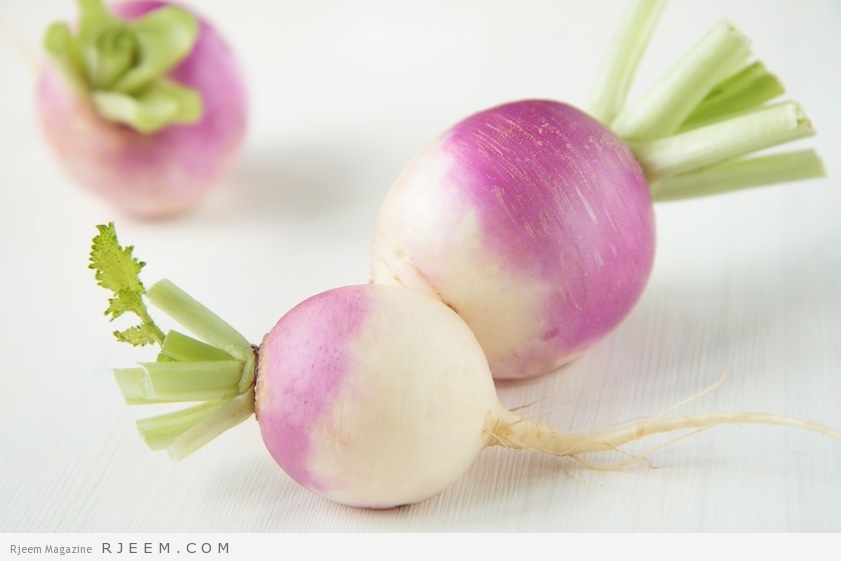 Three turnips with purple skin on table