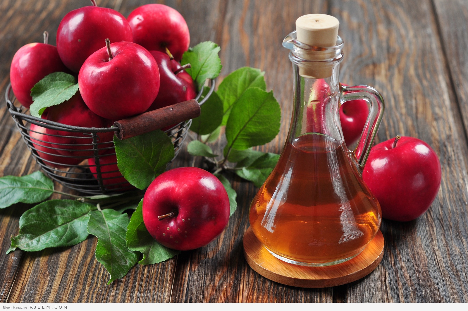 Apple cider vinegar in glass bottle and basket with fresh apples ** Note: Shallow depth of field