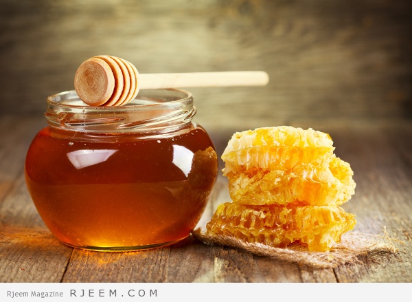 جرة من العسل مع قرص العسل على طاولة خشبية